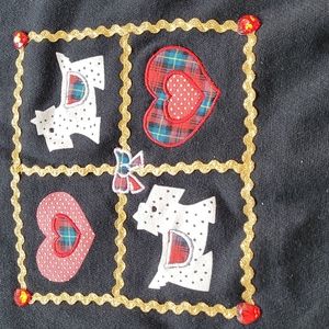 Black sweatshirt with hearts and dogs on front.